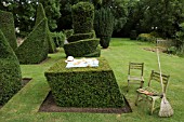 AFTER THE PARTYS OVER. LEANING CUBE WITH TEA PARTY,  PLUS THE TOPIARISTS TOOLS,   TAXUS BACCATA. TOPIARY GARDEN