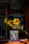 Sunflower, Helianthus, Yellow cut flowers in bucket on patio.