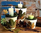 CANDLES IN FLOWERPOTS EMBELLISHED WITH LEAVES