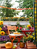 COLOURFUL AUTUMNAL BALCONY WITH CONTAINER PLANTS AND FURNITURE