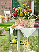 RANUNCULUS AND PANSIES ON GARDEN TABLE