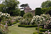 FORMAL BOX-EDGED ROSE GARDEN AND CHURCH AT OZLEWORTH PARK, GLOUCESTERSHIRE
