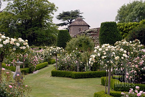 FORMAL_BOXEDGED_ROSE_GARDEN_AND_CHURCH_AT_OZLEWORTH_PARK_GLOUCESTERSHIRE