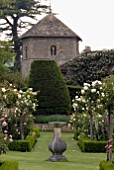 SUNDIAL IN FORMAL BOX-EDGED ROSE GARDEN AND CHURCH AT OZLEWORTH PARK, GLOUCESTERSHIRE