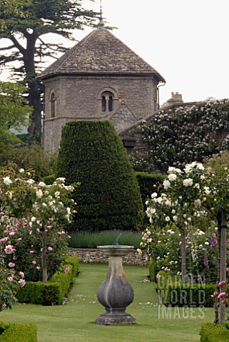 SUNDIAL_IN_FORMAL_BOXEDGED_ROSE_GARDEN_AND_CHURCH_AT_OZLEWORTH_PARK_GLOUCESTERSHIRE
