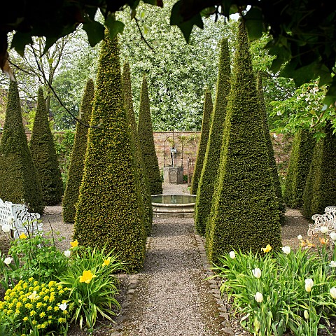 Carved_limestone_wellheadfour_quadrant_beds_are_separated_by_tall_thin_yew_spires