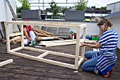 TIKI HUT BAR BUILDING PROJECT ON ROOF.  TIMBER FRAME BEING SCREWED TOGETHER.  STEP 11