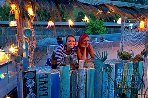TIKI_HUT_BAR_BUILDING_PROJECT_ON_ROOF__LADIES_BEHIND_THE_COUNTER_OF_THE_FINISHED_PROJECT__STEP_26