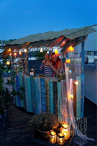 TIKI_HUT_BAR_BUILDING_PROJECT_ON_ROOF__LADIES_BEHIND_THE_COUNTER_OF_THE_FINISHED_PROJECT__STEP_27
