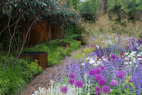 TELEGRAPH_GARDEN__DES_TOM_STUART_SMITH_PATHWAY__RUSTED_STEEL_WATER_TANKS_WITH_VIBURNUM_RHYTIDOPHYLLU