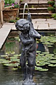 CHERUB WITH FISH FOUNTAIN,  NYMPHAEA MARLIACEA CARNEA BEHIND. CHRIS BEARDSHAW WORMCAST GARDEN   GROWING FOR LIFE AT BOVERIDGE HOUSE