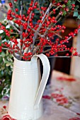 WHITE JUG FILLED WITH ILEX BERRY STEMS