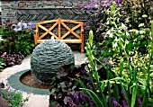SMALL GARDEN WITH SLATE WATER SPHERE, WOODEN BENCH,  GALTONIA CANDICANS
