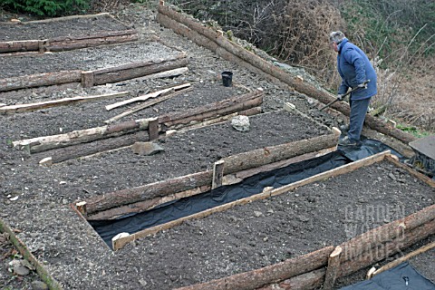 RAISED_BEDS_RAKING_OUT_THE_STONE_FOR_THE_PATHS