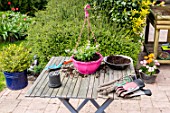 Making of a flowered hanging basket in a garden