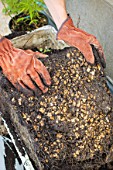 Bottom of a flower container showing stones for drainage