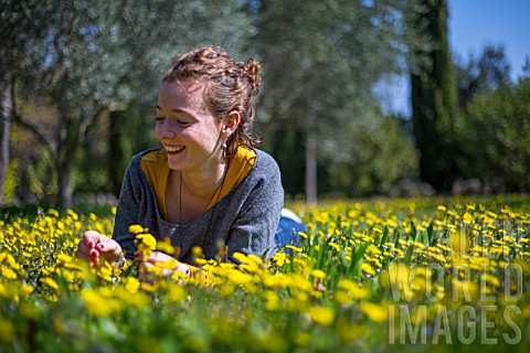 Young_woman_with_Dandelion_flowers_in_a_garden