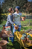 Young couple with aromatic plants in a garden