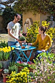 Young couple with flowers in a garden terrace