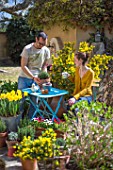 Young couple with flowers in a garden terrace