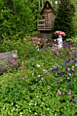 Aquilegia flowers and mushroom sculpture, Garden for Peace in Bitche , Lorraine, France