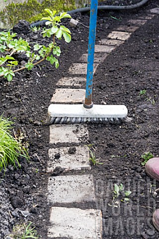 Sowing_a_lawn_on_a_garden_path