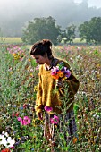 Young woman making a bouquet in a flower meadow