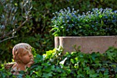 Clay angel and Myosotis in planter, Provence, France