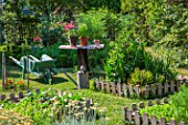 Vegetable garden squares, wheelbarrow, small table and aromatic plants in June, Provence, France