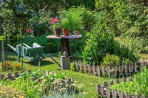 Vegetable_garden_squares_wheelbarrow_small_table_and_aromatic_plants_in_June_Provence_France