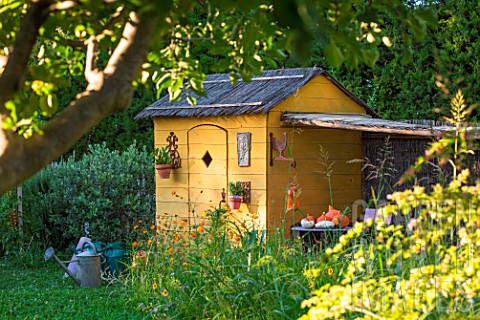 Garden_shed_with_squash_and_seating_area_in_July_Provence_France