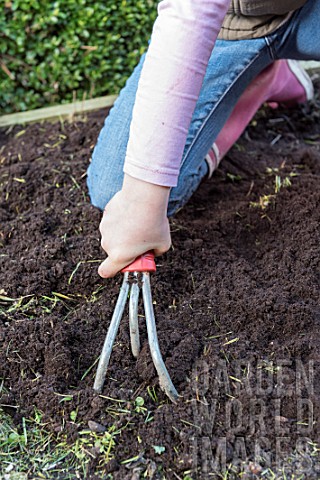 Young_girl_loosening_the_soil_of_the_squarefoot_kitchen_garden