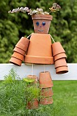 Character in terracotta pots on a fence