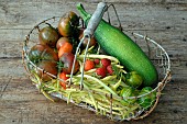 Harvest from the vegetable garden: courgette (Cucurbita pepo), butter beans (Phaseolus vulgaris), tomatoes (Solanum lycopersicum) and Garden strawberry (Fragaria × ananassa)