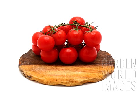 Several_red_ripe_tomatoes_on_a_cutting_board_on_a_light_background