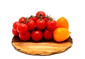 Several red and yellow ripe tomatoes on a cutting board on a light background. Natural product. Natural color. Close-up.