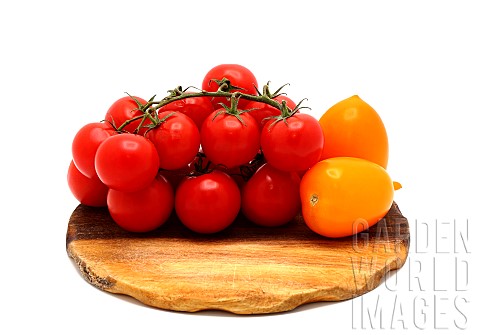 Several_red_and_yellow_ripe_tomatoes_on_a_cutting_board_on_a_light_background_Natural_product_Natura