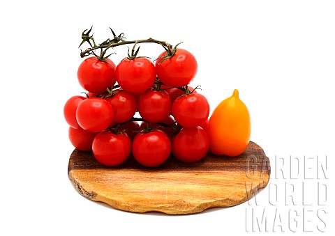Several_red_and_yellow_ripe_tomatoes_on_a_cutting_board_on_a_light_background_Natural_product_Natura