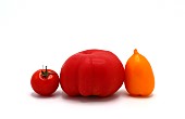 Several red and yellow ripe tomatoes on a light background. Natural product. Natural color. Close-up.