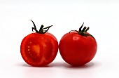 Half ripe tomato and a whole red tomato on a light background. Natural product. Natural color. Close-up.