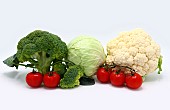 Head of cabbage, inflorescences of broccoli and cauliflower and red ripe tomatoes on a light background. Natural product. Natural hue. Close-up.