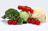 Head of cabbage, inflorescences of broccoli and cauliflower and red ripe tomatoes on a light background. Natural product. Natural hue. Close-up.