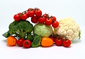 Head of cabbage, inflorescences of broccoli and cauliflower and red and yellow ripe tomatoes on a light background. Natural product. Natural hue. Close-up.