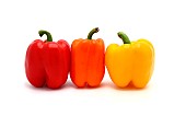 Three ripe sweet peppers of red, yellow and orange color on a light background. Natural product. Natural color. Close-up.