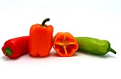 Composition of several sweet peppers and their halves of different colors on a light background. Natural product. Natural color. Close-up.