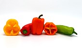 Composition of several sweet peppers and their halves of different colors on a light background. Natural product. Natural color. Close-up.