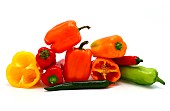 Composition of several sweet peppers and their halves of different colors on a light background. Natural product. Natural color. Close-up.