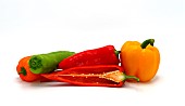 Composition of several sweet peppers and their halves of different colors on a light background. Natural product. Natural color. Close-up.