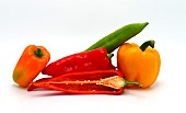 Composition of several sweet peppers and their halves of different colors on a light background. Natural product. Natural color. Close-up.