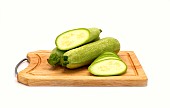 Whole and cut zucchini on a cutting board on a light background. Natural product. Natural color. Close-up.